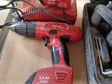 two electric tools sitting on a table next to a tool case