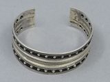 a close up of a silver bracelet on a white surface