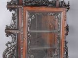 a wooden cabinet with a glass door and a shelf
