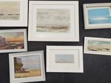 a lot of framed pictures on the wall of a room