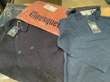 deux vestes et un t-shirt posés sur une table dans un magasin