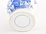 a blue and white vase on a white surface