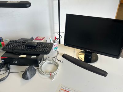 un écran d'ordinateur, un clavier, une souris et un tapis de souris posés sur un bureau