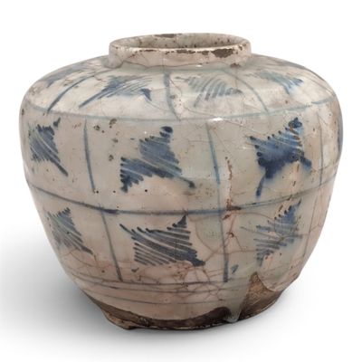 un vase bleu et blanc posé sur une surface blanche