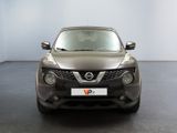 the front view of a silver nissan suv parked in a showroom