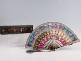 a fan and a box sitting on a white surface