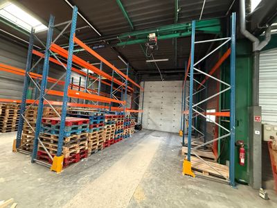 a large warehouse with pallets of wood in the middle of the room