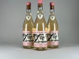 trois bouteilles de vin sont alignées sur une surface blanche