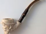 une pipe surmontée d'une tête d'homme coiffée d'un chapeau