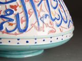 a blue and white vase with arabic writing on it