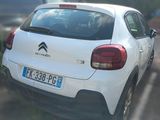 a small white car parked on the side of the road