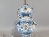 une lampe bleue et blanche surmontée d'un oiseau