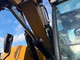 the back end of a large yellow construction vehicle parked on the side of the road