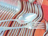 a tray with silverware and spoons on it on a table