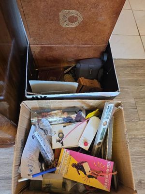 a box full of books on the floor next to a chair