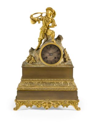 une horloge en or surmontée d'une statue