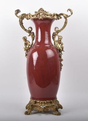 un grand vase rouge orné de motifs dorés
