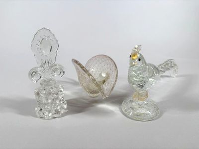 three glass figurines sitting on a white surface