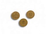 three gold coins are shown on a white surface