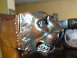 a statue of a lion head on a wooden chair