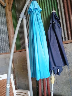 deux parapluies suspendus à un poteau dans une pièce