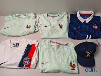 tout un tas de t-shirts et de casquettes différents posés sur une table