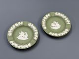 two green and white plates with white designs on them
