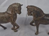 paire de figurines anciennes représentant des chevaux, en bois, sur fond blanc