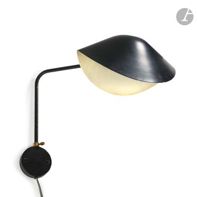 a black and white lamp on a wall next to a white wall