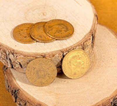 three coins sitting on a piece of wood on a table