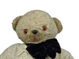 a teddy bear that is wearing a sweater and a bow tie