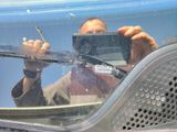 a man taking a picture of himself in the mirror of a car