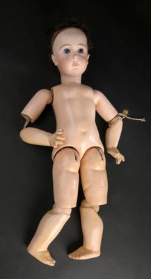 une poupée en bois qui tient un couteau dans la main