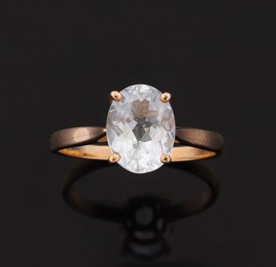 une bague en diamant blanc avec un anneau en or sur fond noir
