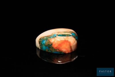 une image d'une bague ornée d'une pierre bleue et orange