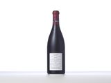 a bottle of red wine sitting on top of a white table
