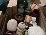 une boîte remplie de vases posée par terre dans une pièce