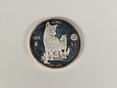 a silver coin with a picture of a dog and a cat on it
