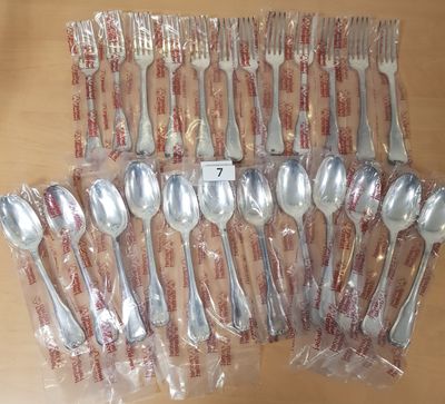 de nombreuses fourchettes et cuillères emballées dans des sachets en plastique, posées sur une table