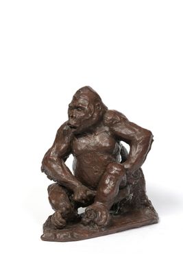 une statue en bronze représentant un singe assis sur un rocher