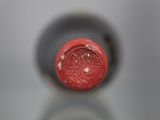 a close up view of a wine bottle with a red cap