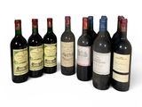 plusieurs bouteilles de vin sont alignées sur une surface blanche
