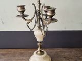 an antique brass candelabra with marble base on a wooden table