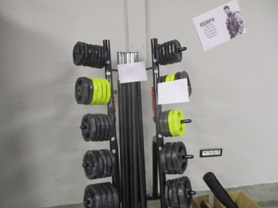 une photo d'un support pour matériel de musculation avec une paire d'haltères