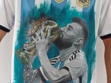 un footballeur tenant un trophée devant un mur blanc