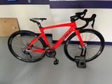 a red bike that is parked in a room