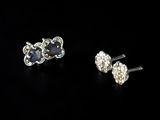 a pair of sapphire and diamond earrings on a black background