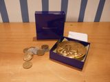 une pièce d'or et une boîte violette posées sur une table en bois