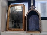 deux miroirs posés sur une étagère devant une fenêtre
