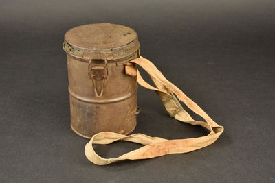a brown tin with a strap around it on a black surface